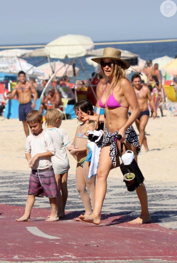 Fernanda Lima deixa a praia com os filhos