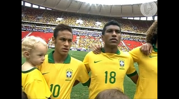 Neymar durante o hino nacional do jogo do Brasil contra a Austrália, que termino em 6 a 0. O craque segurava no colo o seu filho Davi Lucca, de 2 anos