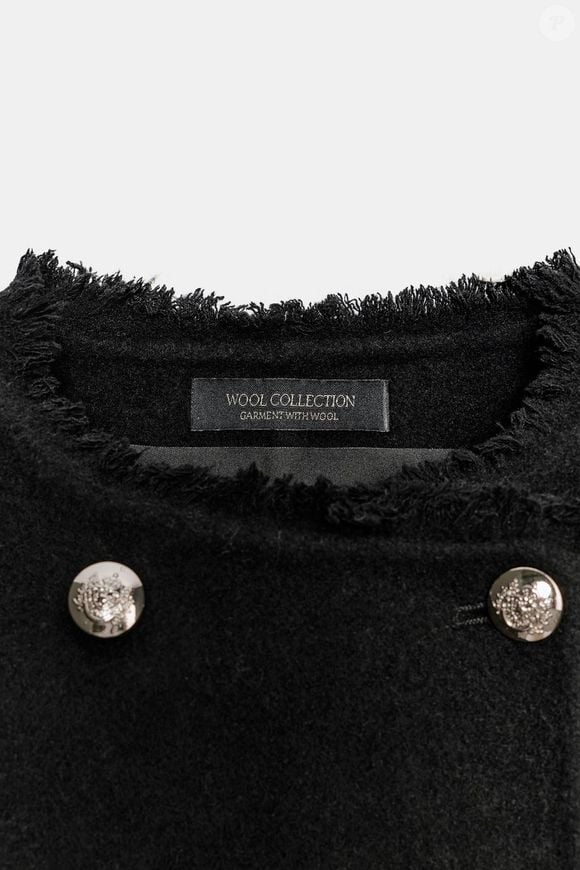 Com tecido que mistura lã, o casaco preto da Zara reúne praticidade e detalhes sofisticados, como os botões metálicos e os acabamentos desfiados