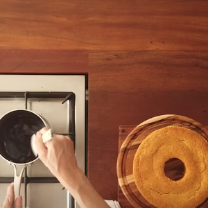 Para a calda, misture na panela açúcar, chocolate em pó, água e manteiga. Leve ao fogo médio até tudo ficar lisinho e brilhante
