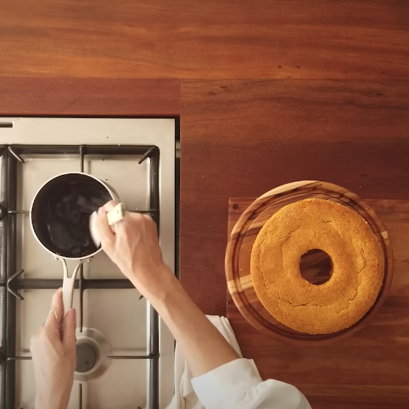 Para a calda, misture na panela açúcar, chocolate em pó, água e manteiga. Leve ao fogo médio até tudo ficar lisinho e brilhante