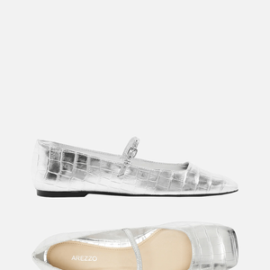 Na Arezzo, a Sapatilha Metalizada Tira aparecia por R$ 149,90 até o fechamento desta matéria. O modelo tem salto rasteiro, bico quadrado, cabedal com recorte reto e tira afivelada sobre o peito do pé, exibindo toda a região frontal e valorizando o design clean