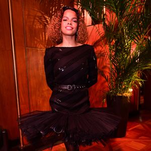 Jennifer Nascimento: a atriz e cantora apostou na estética 'balletcore' com um toque gótico, utilizando um vestido preto de mangas longas com listras de brilho diagonais e uma saia de tule volumosa estilo tutu. O cinto fino de couro marcou a cintura, criando um visual que equilibra a delicadeza da bailarina com a atitude urbana das passarelas internacionais