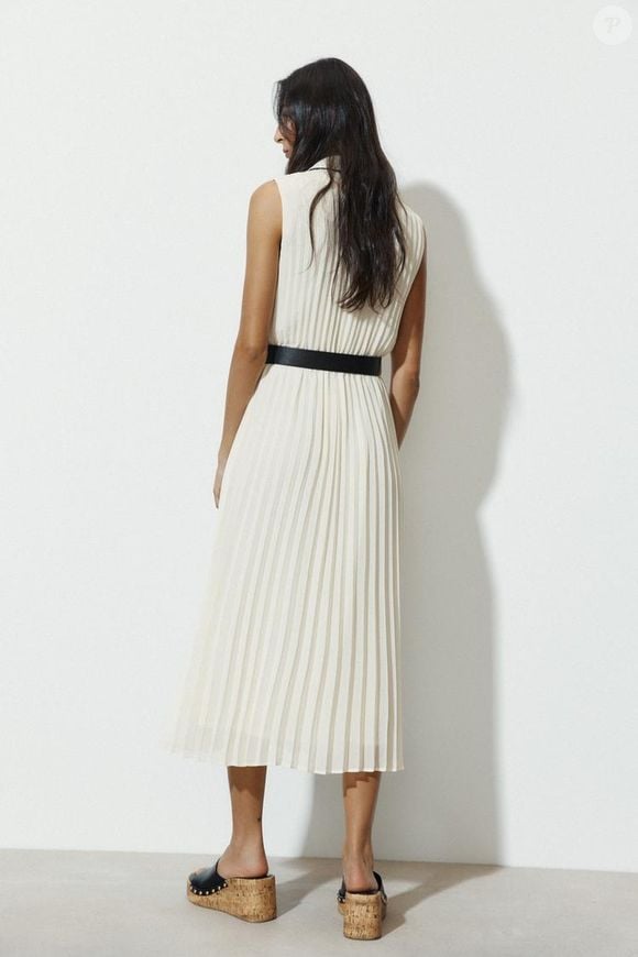 O vestido branco plissado equilibra elegância e discrição, com aquele ar polido que é marca registrada de Victoria Beckham