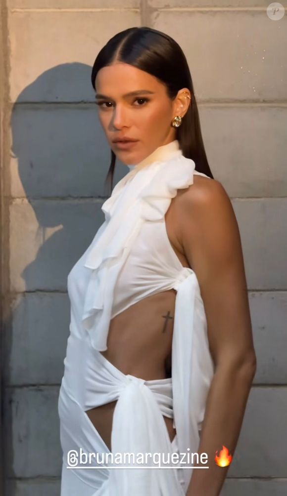 A silhueta que abraça o corpo é definida por um design assimétrico, uma gola alta com laço e recortes laterais sedutores.