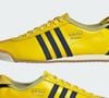 Apesar da cor chamativa, o visual é equilibrado pelos detalhes em azul-marinho nas icônicas três listras da Adidas e no calcanhar