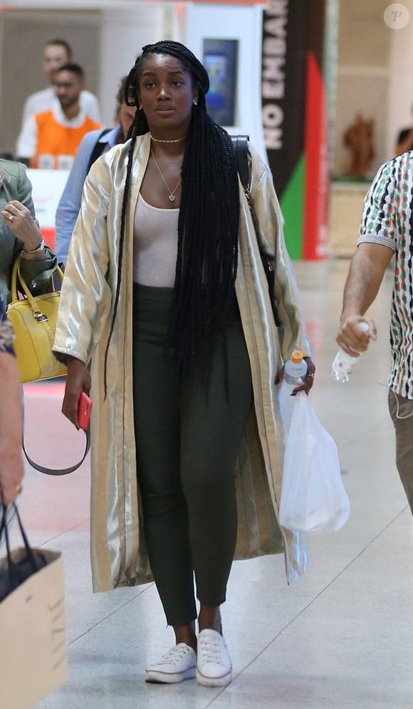 A cantora Iza apostou em blusa de lurex com transparência, calça de cintura alta, tênis rasteiro e um maxikimono ao viajar