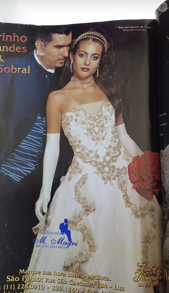 10. Vestido Tomara que caia

Aqui, temos uma noiva mais sensual e glamourosa, mas sem perder a grandiosidade da época. O vestido é tomara que caia com bordados dourados em arabescos florais que descem pelo corpete e se espalham pela saia em forma de cascata, criando um efeito de movimento e leveza.

A saia rodada carrega a tradição volumosa, mas o desenho do bordado alonga e valoriza a silhueta. As luvas longas brancas adicionam um toque clássico, enquanto o styling traz um colar e tiara dourados, em um mood mais minimalista em comparação aos outros dois. O buquê vermelho contrasta de forma ousada com o dourado e o branco, trazendo um impacto visual típico das noivas ousadas do início dos anos 2000.