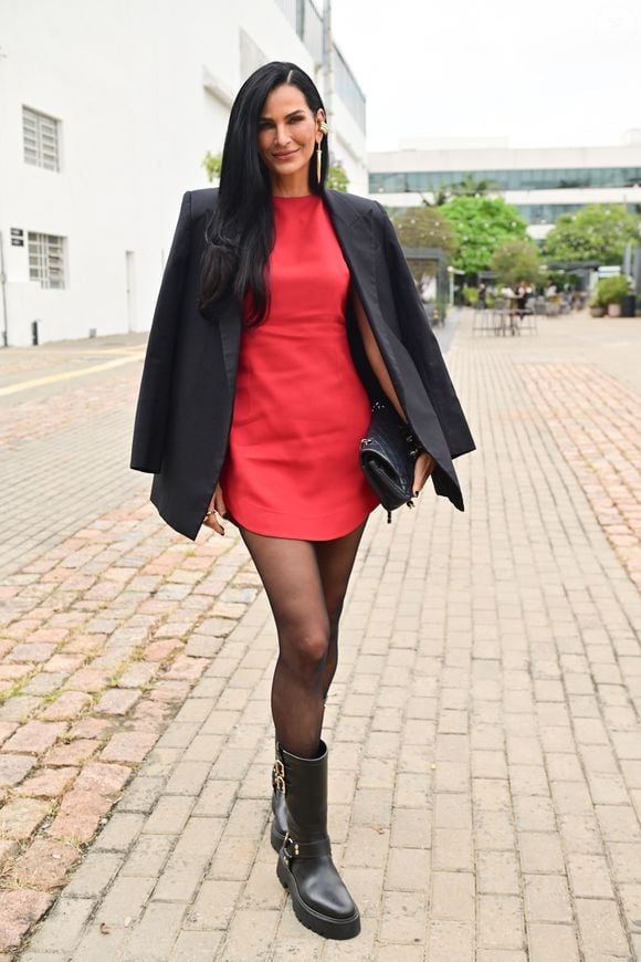 Apresentadora e modelo, Fernanda Motta escolheu um vestido curto vermelho com um blazer preto e meia-calça semitransparente para o desfile