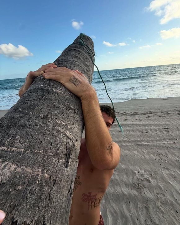 Na 3ª foto publicada por João Guilherme, ele aparece por baixo, segurando o tronco da árvore.