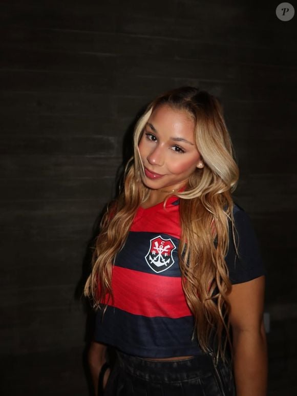 A ginasta Flavia Saraiva é uma referência para quem gosta de associar o universo esportivo à paixão pelo futebol. Uma combinação com camisa do Flamengo e tênis New Balance 9060 Preto Vermelho pode reunir elementos esportivos e casuais em um look com as cores rubro-negras