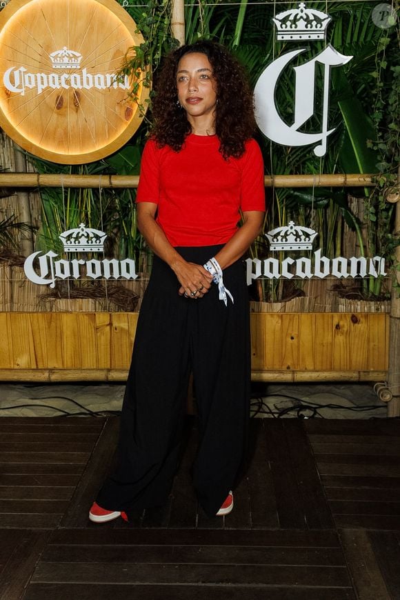 Alice Carvalho não ousou no look e posou com uma calça wide leg preta com camiseta vermelha simples