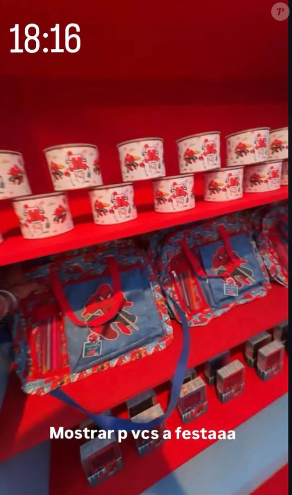 As lembrancinhas da festa foram organizadas em prateleiras com nichos de fundo vermelho, compondo também a decoração do ambiente