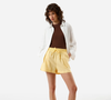 O short de linho amarelo da C&A, por R$ 119,99, traz uma dose de cor ao visual e cria um contraste interessante com o acabamento em denim do Adidas Tokyo Jeans