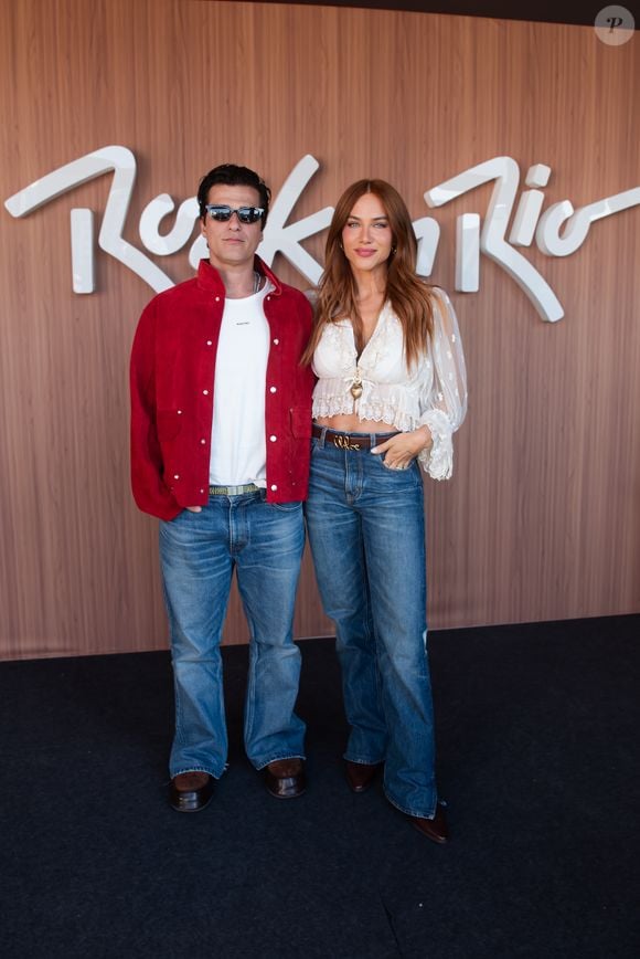 Bruno Gagliasso e Giovanna Ewbank: o ator usa jaqueta bomber em camurça vermelha sobre t-shirt branca, jeans flare de lavagem média e bota de couro escura. A apresentadora aposta na estética boho chic com bota de bico fino, jeans de cintura alta com cinto de fivela marcante e bota no tom café, além de cropped branco de mangas bufantes e transparência em polka dots