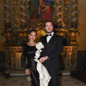 Com Thiago Nigro, Maira Cardi surgiu com um vestido preto com aplicação de flor no ombro e babados esculturais em tom off-white que descem em cascata pela lateral do corpo