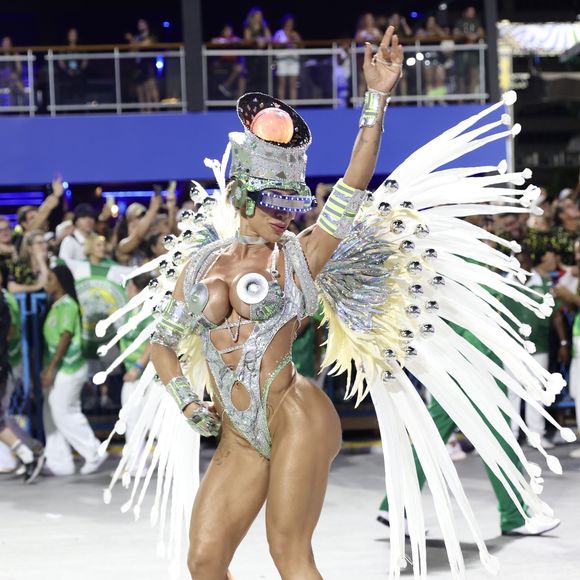 Seu traje é composto por um body adornado com acessórios tecnológicos, sandálias gladiadoras e um adereço de cabeça iluminado