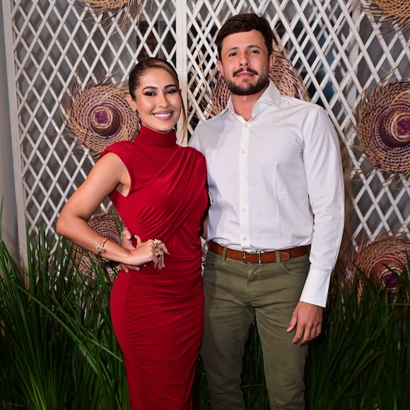 Thaynara OG e André Ferraz: a anfitriã surgiu deslumbrante em um vestido longo drapeado vermelho de gola alta e silhueta ajustada, combinado com sapatos nude. Ao seu lado, o acompanhante escolheu a sobriedade com camisa social branca de punhos estruturados, calça de sarja verde-oliva, cinto e sapatos marrons