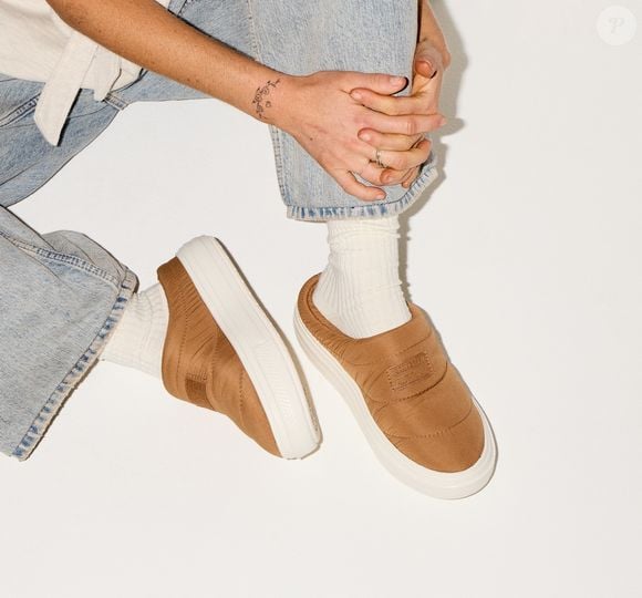 O Mule Chuck Taylor All Star, da Converse, aposta no formato slip-on, que deixa o calçado fácil de colocar e retirar, enquanto a construção em camurça resistente acrescenta uma aparência mais sofisticada ao modelo