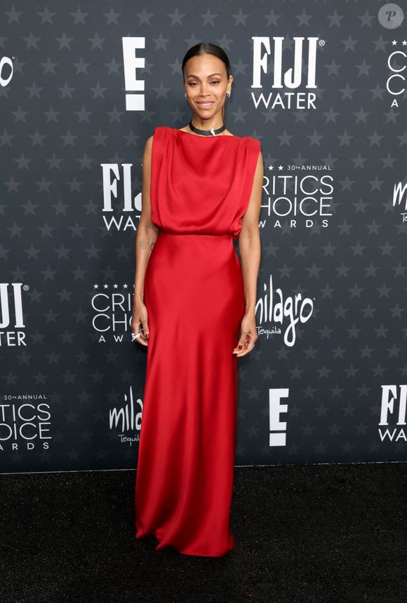 Zoe Saldaña chegou com um elegante vestido longo de seda Saint Laurent e uma gargantilha Cartier com joias no Critics Choice Awards 2025