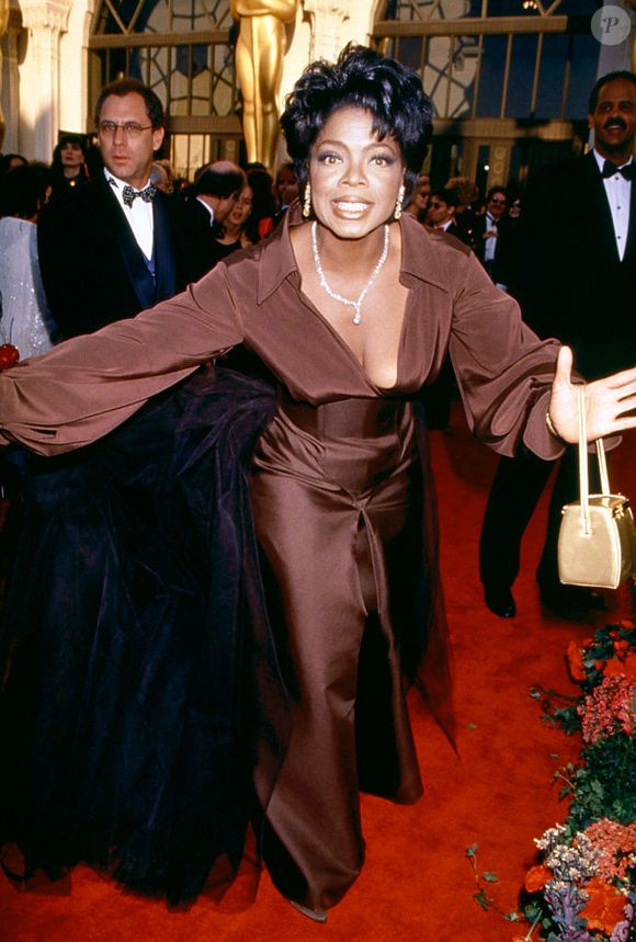 Oprah Winfrey estava radiante no Oscar de 1995, vestida com um traje de seda cor de café, uma bolsa dourada e muitos acessórios de diamantes.
