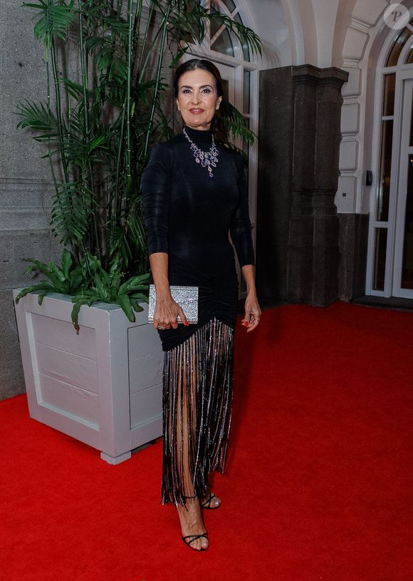 Fátima Bernardes apostou na tendência do 'brilho textural' com um vestido preto de gola alta e mangas 3/4. O corpo da peça é liso e ajustado, mas o grande protagonista é a barra composta por longas franjas de canutilhos prateados, que criam um movimento hipnotizante a cada passo no tapete vermelho