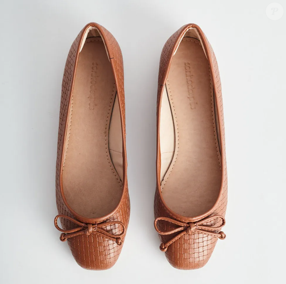 A sapatilha com laço trassê, na cor marrom, da Sonho dos Pés, transmite leveza e uma sensação romântica, quando combinada ao seu look do dia.