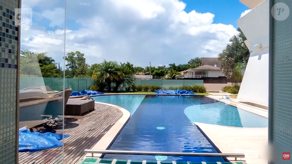 Piscina e paisagismo com irrigação artificial compõem a área externa da propriedade. A mansão de 2.400 m² de terreno está localizada em um condomínio reservado do Setor de Mansões Dom Bosco