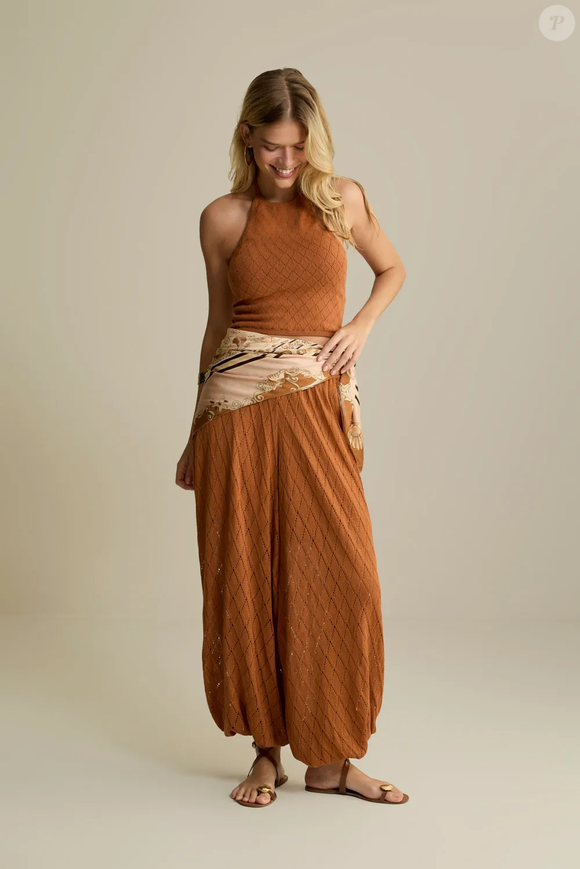 A modelagem ampla e fluida é o destaque desta calça da Oh, Boy!, que aposta em padronagem geométrica rendada, leve transparência e silhueta Alladin. Em tricô, o modelo combina textura e movimento e pode ser usado com tops da coleção ou peças de linho. O preço é de R$ 699