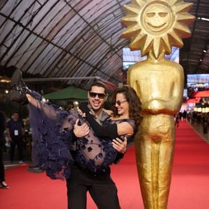 Fernanda Marques e José Loreto chamaram atenção no tapete vermelho de Gramado com beijo e looks contrastantes: ela apostou em transparência e flores 3D; ele, em alfaiataria cinza e preta