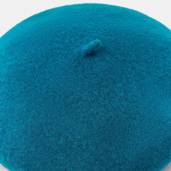 Seguindo as inspirações vistas nas telas e nas ruas, a boina aparece como aquele detalhe que transforma o visual com pouco esforço. O modelo em lã no tom verde-azulado funciona perfeitamente como ponto de cor em produções neutras, criando um contraste elegante e moderno sem exageros