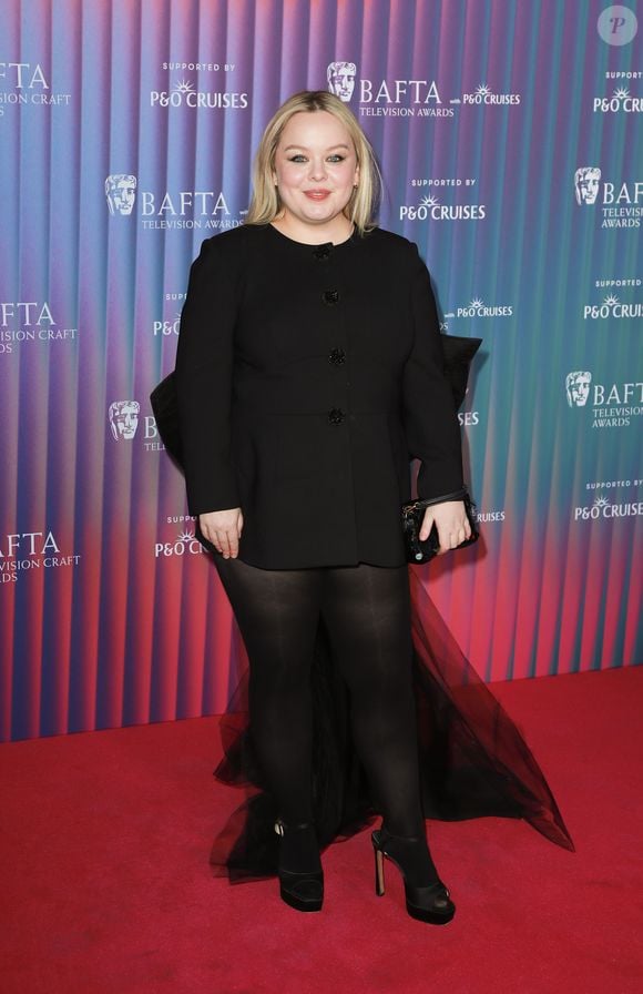 Nicola Coughlan usou meia-calça e saltos pretos