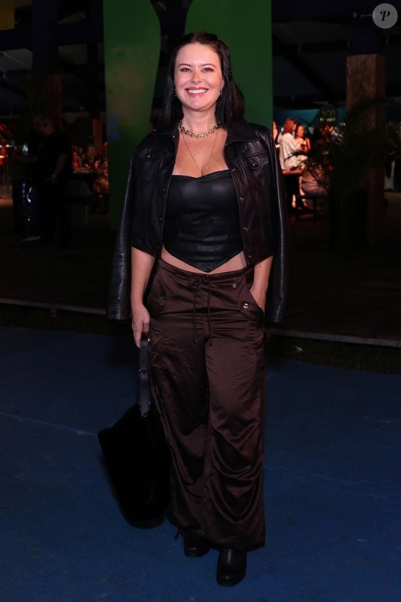 Mari Bridi: A influenciadora seguiu a tendência utilitária noturna ao vestir um corset de couro preto com decote estruturado sob uma jaqueta de couro curta jogada sobre os ombros. Na parte inferior, uma calça cargo de tecido acetinado marrom escuro com amarrações trouxe textura ao look, finalizado com maxibolsa preta de pelúcia e botas escuras