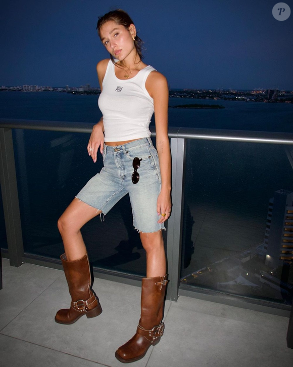 Sasha Meneghel combina regata branca de grife com bermuda jeans e bota