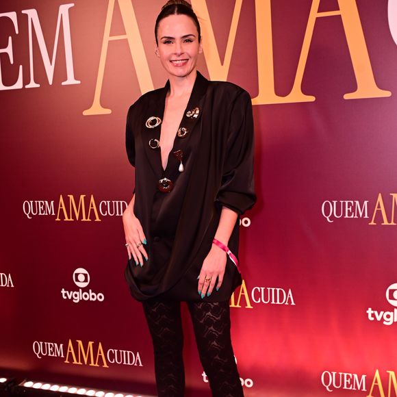 Com uma proposta moderna, Ana Paula Renault vestiu um blazer oversized preto de decote profundo decorado com broches esculturais, combinado a uma calça de renda trabalhada e sapatos de bico fino