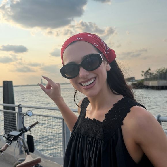 Dua Lipa também aderiu à tendência da bandana na cabeça, combinando o acessório com óculos de sol oversized para reforçar a estética 'Dolce nonna' e criar um visual inspirado nas mulheres italianas