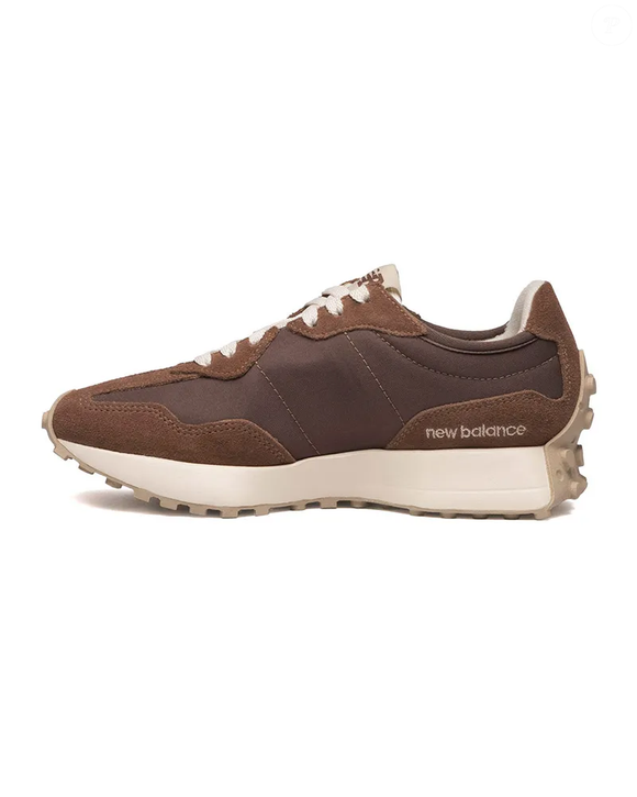 O tom marrom do New Balance 327V1 harmoniza com as tonalidades terrosas dos trench coats, criando uma combinação versátil para renovar os looks de primavera