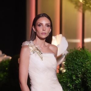 Mãe da debutante, Carol Celico apostou em um vestido branco de tecido leve e texturizado, destacado pela aplicação floral dourada no ombro