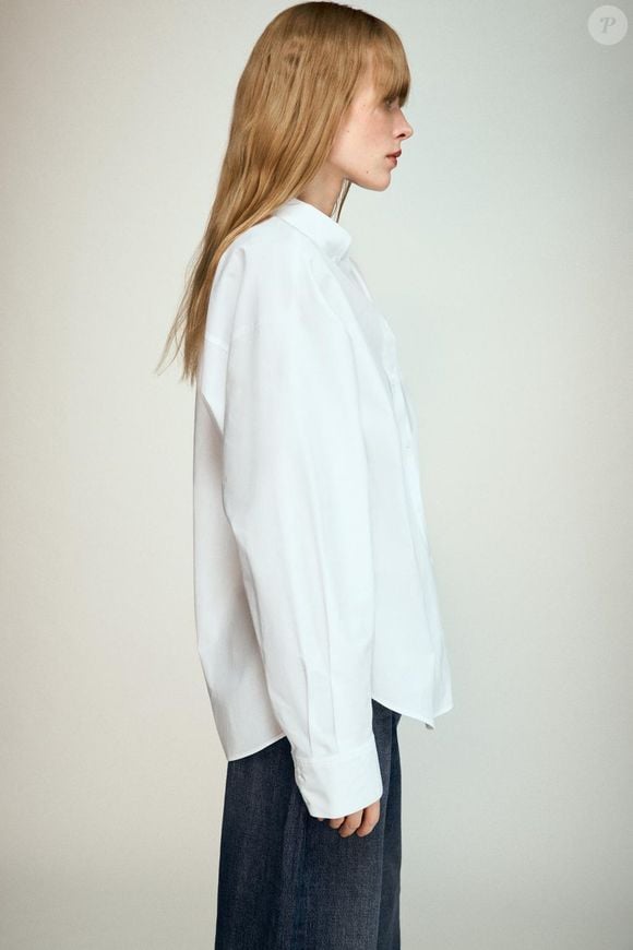 Disponível na cor branca, a Camisa de Popelina com Bolso da Zara combina gola com lapela, mangas amplas acabadas em punho e bolso de patch na parte da frente
