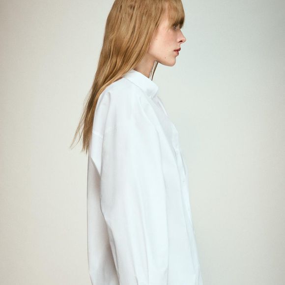 Disponível na cor branca, a Camisa de Popelina com Bolso da Zara combina gola com lapela, mangas amplas acabadas em punho e bolso de patch na parte da frente