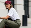 Um exemplo simples de look com os New Balance 480 Low seria calça cargo ou de alfaiataria verde oliva, uma t-shirt branca que conversa com a sola do tênis e um boné ou acessório no mesmo tom vinho do calçado