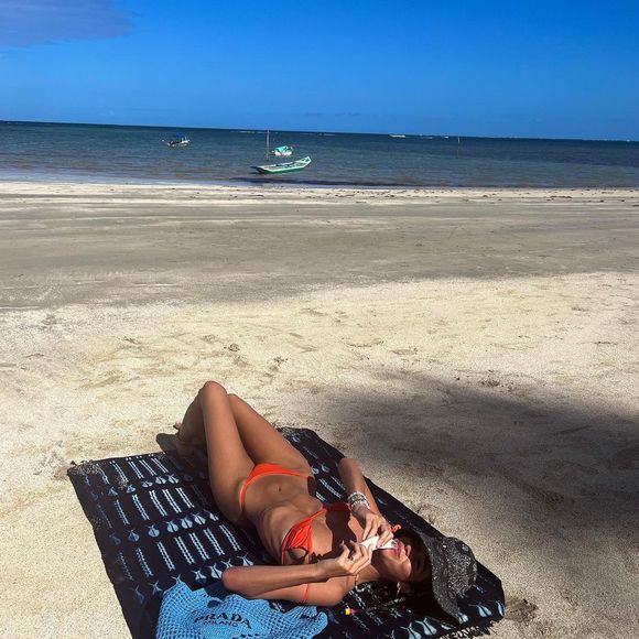 De biquíni coral, Bruna Marquezine exibiu a barriga trincada em um dia de muito sol e praia.