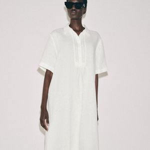 O vestido camisa de linho da Zara traduz o minimalismo japonês com uma proposta leve e sofisticada, combinando modelagem soltinha, gola com lapela, mangas curtas e fechamento frontal por botões. O modelo custa R$ 439,00