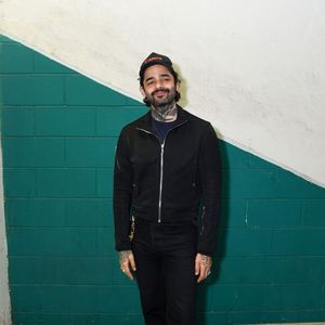 Lucas Silveira apostou em uma produção all black urbana e sóbria, combinando uma jaqueta de zíper com corte ajustado e calça preta de caimento reto. O músico complementou o visual básico com um boné preto bordado e calçados em tom marrom caramelo, que trouxeram contraste ao look