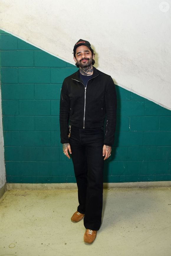 Lucas Silveira apostou em uma produção all black urbana e sóbria, combinando uma jaqueta de zíper com corte ajustado e calça preta de caimento reto. O músico complementou o visual básico com um boné preto bordado e calçados em tom marrom caramelo, que trouxeram contraste ao look