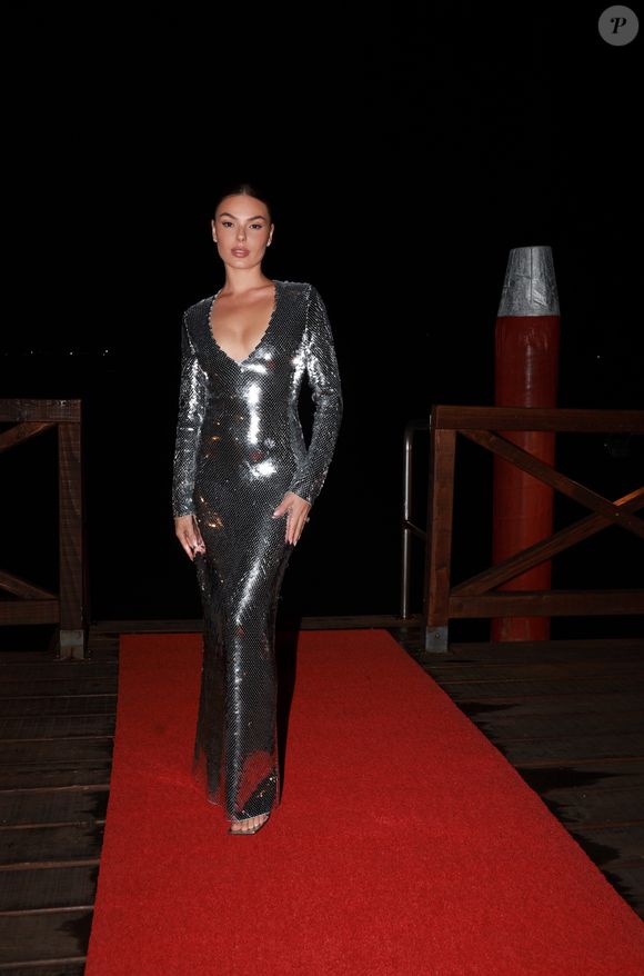 O modelo escolhido tem mangas longas, decote profundo em V e caimento reto e sofisticado até os pés, valorizando a silhueta da atriz. Para complementar o visual, a mineira apostou em uma sandália de tiras transparentes, quase invisível sob o vestido, mas que garantiu leveza ao styling