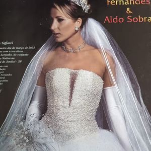 3. Vestido perolado com decote profundo

Aqui temos a tradução da noiva glamourosa dos anos 2000. O corpete é todo bordado com microcristais prateados, criando um efeito cintilante sob a luz. O decote em tule transparente desce em um corte profundo em “V”, ousadia na medida certa. A saia volumosa mantém a tradição, mas o destaque está mesmo no brilho extremo da parte superior. O véu longo e a tiara cravejada completam esse look de princesa moderna da época.