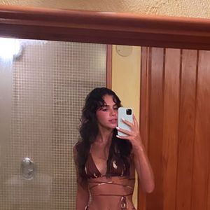 Bruna Marquezine posou no espelho durante uma viagem exibindo a barriga trincada em um biquíni super diferente, em tons terrosos com amarração na cintura.