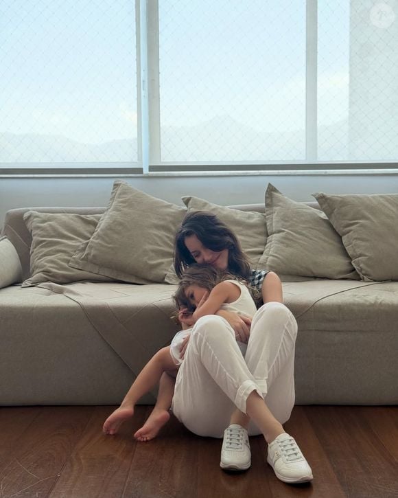 Um dos cantinhos mais acolhedores do apartamento de Nathalia Dill tem como destaque um amplo sofá off-white, que aparece em registros da atriz ao lado da filha, Eva. O móvel reforça a proposta clean da decoração e ajuda a criar um ambiente confortável para os momentos em família, cercado por tons claros e objetos decorativos delicados