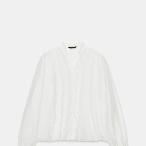 Em tom cru, a Camisa com Babados da Zara tem gola redonda com decote V, mangas amplas e detalhes de babados no mesmo tecido